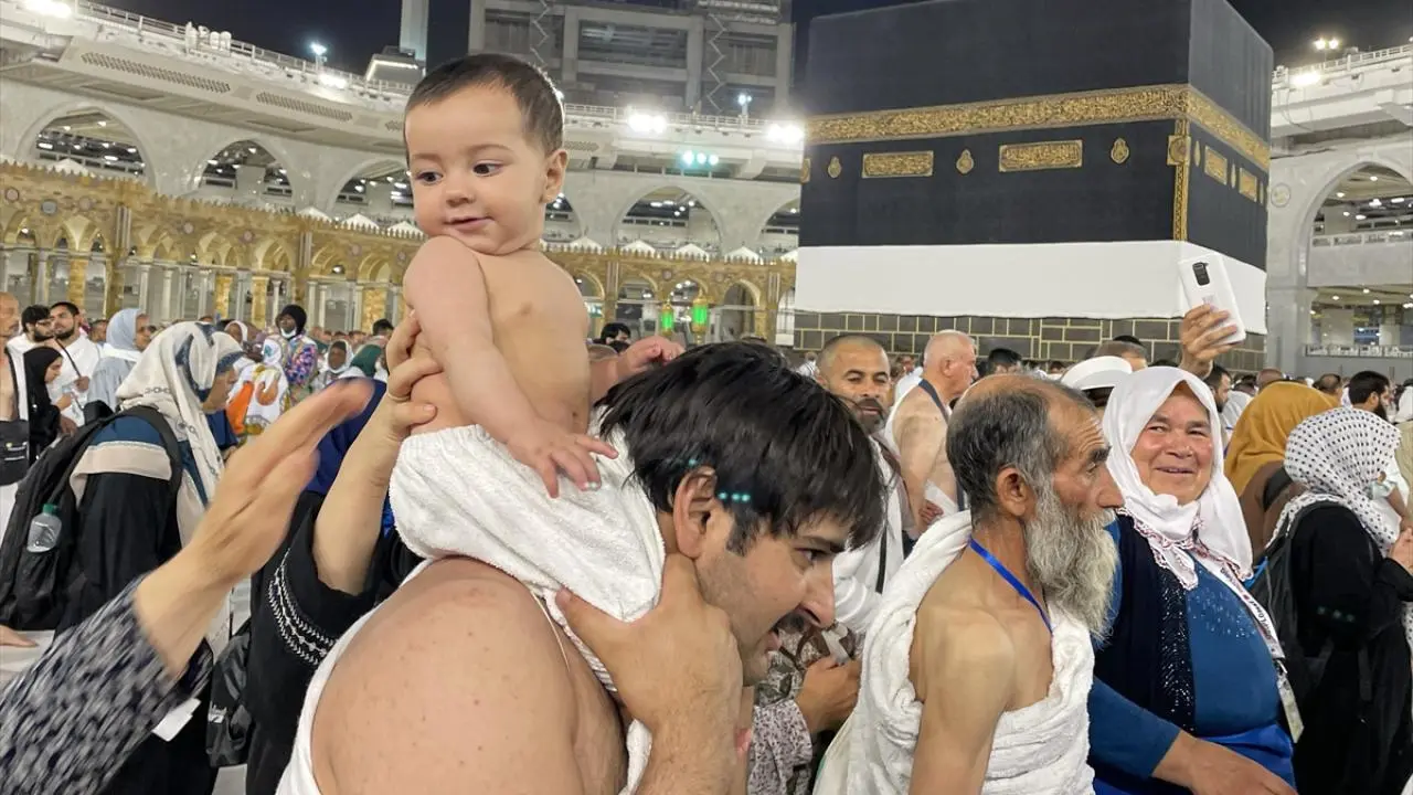 Muslim pilgrims performing Umrah at the Kaaba in Makkah with a baby on shoulders – a spiritual family moment during Umrah 2025, representing the journey after obtaining the Umrah Visa from UK.