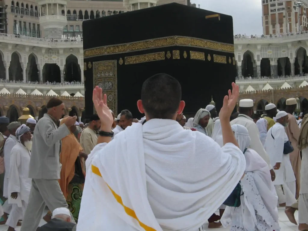 A pilgrim making heartfelt dua during Umrah, seeking forgiveness and spiritual blessings – representing the spiritual benefits of Umrah
