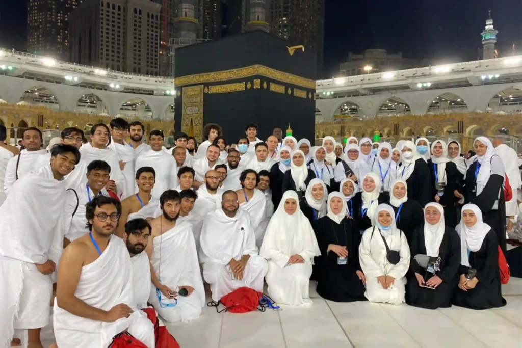 Group of Umrah pilgrims posing together in front of Masjid al-Haram – Group Umrah Packages
